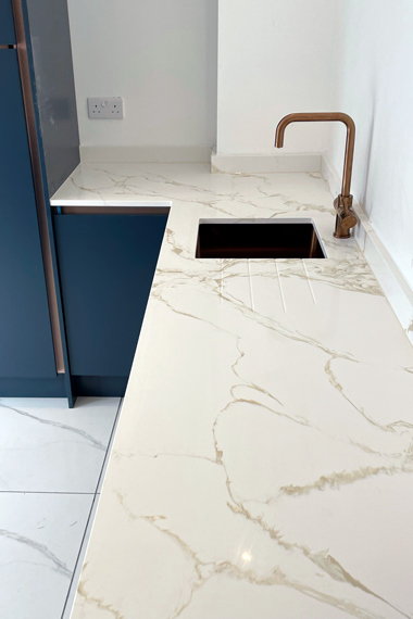 white marble quartz worktop modern kitchen blue cupboards copper sink
